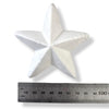 A white polystyrene five-pointed star ornament shown above a metal ruler for scale on a white background.