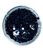 A clear container filled with black hexagonal chunky glitter.