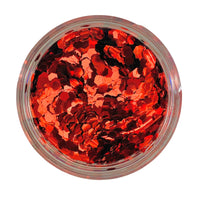 A clear container filled with red hexagonal chunky glitter.